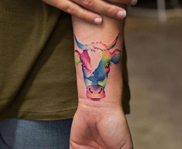 unique colored Taurus tattoo on a girl’s hand for stylish look