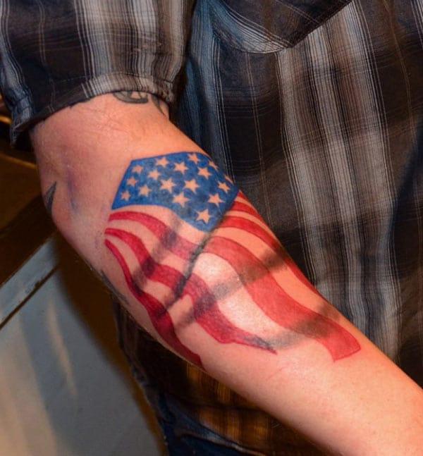American Flag Tattoo on the back lower arm gives men ostentatious look