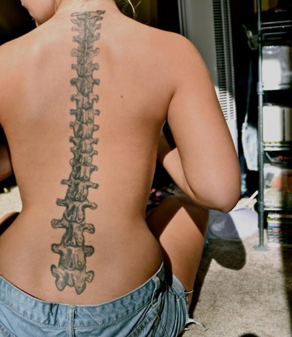 Spine tattoo along the back makes a woman appear fabulous and adorable