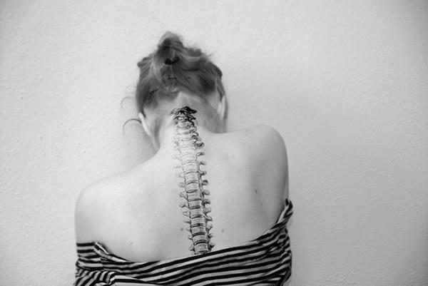 Spine tattoo on the neck towards the back makes a girl look ravishing
