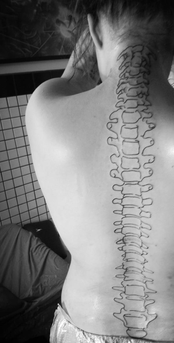 Spine tattoo on the neck along the back brings the radiant look