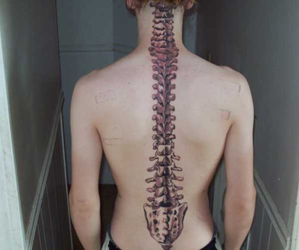 Spine tattoo from the neck along the back makes a girl look charming