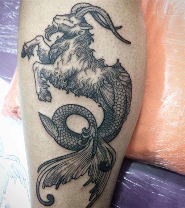 The dark design ink of the Capricorn tattoo on the foot matches the skin color give a man a dapper look