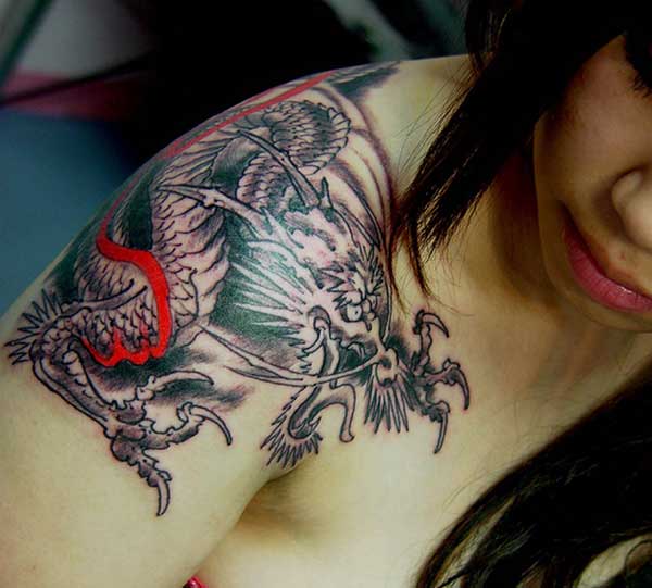 stunning colorful dragon tattoo on the woman's shoulder