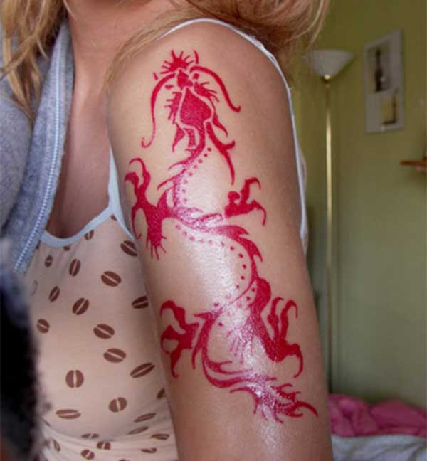 beautiful red ink dragon tattoo design on the girl's shoulder