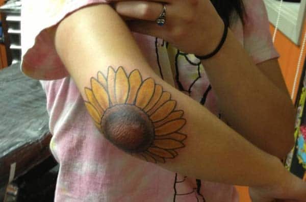 cute sunflower tattoo ink on the girl elbow