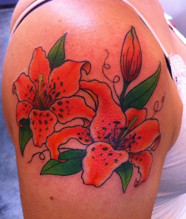 This Lily tattoo design with a colorful pink and green ink makes the right arm look fabulous