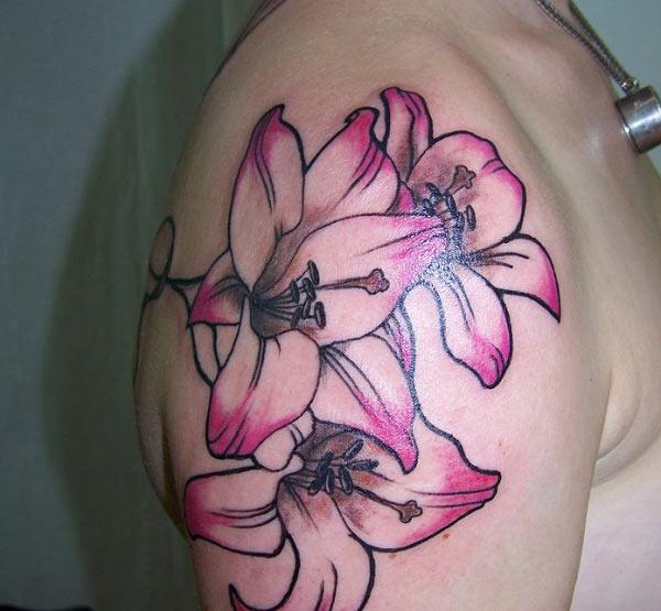 Lily tattoo on the shoulder with a purple ink design make a man look stylish