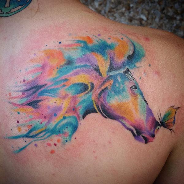 Watercolor tattoo on the back with a horse design makes a girl look pretty and attractive
