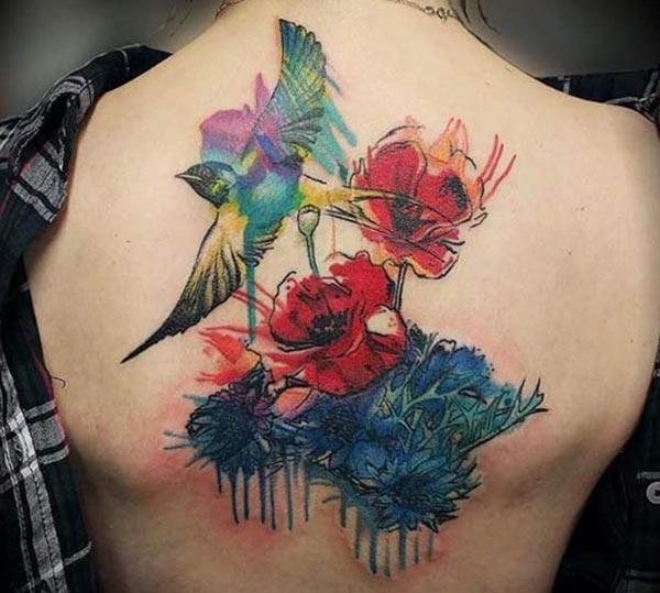 Watercolor tattoo on the back makes a woman look captivating