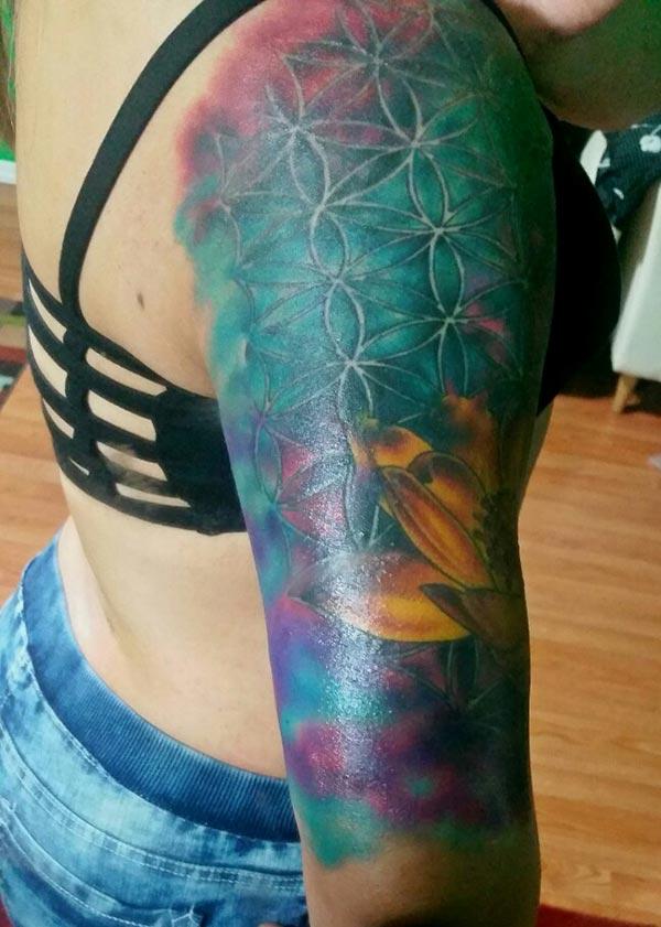 Watercolor tattoo on the upper arm makes ladies appear radiant