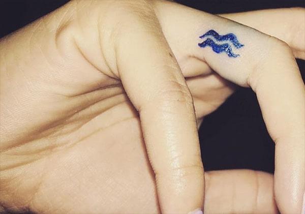 Dark and embossed Aquarius tattoo on your beautiful and sleek fingers