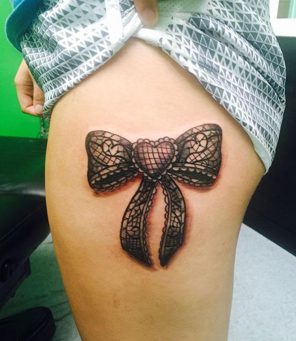 Bow tattoo on the side thigh gives the girls an attractive look