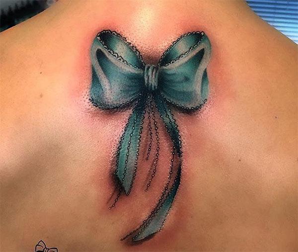 Bow tattoo on the back make a girl attractive and elegant