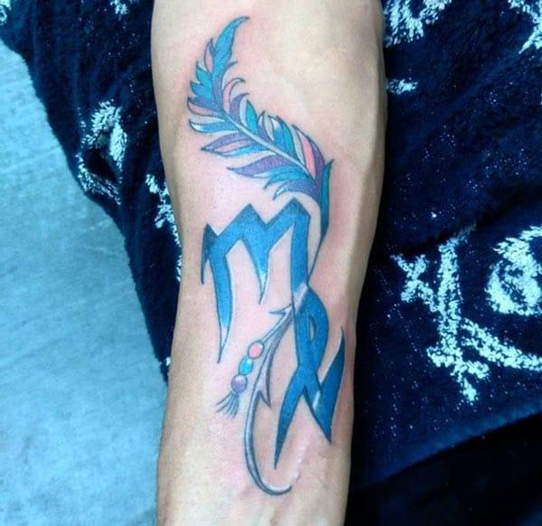 Virgo tattoo with a blue ink design on the lower arm shows their foxy look