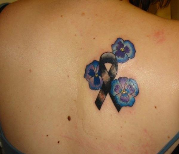 Cancer Ribbon tattoo on the back with a black ink design gives the dire look