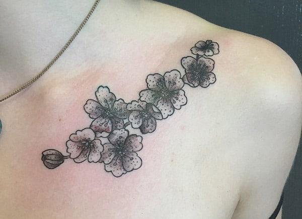Collar Bone Tattoo with a black flower ink design make them look attractive