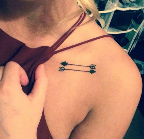 Collar Bone Tattoo with black arrows makes a girl look so cute