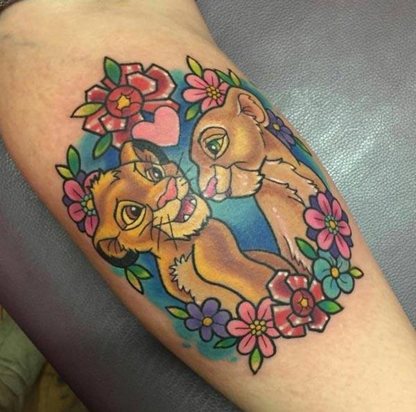 Disney Tattoo on the lower arm with a pink flower ink design makes a man appear charming 
