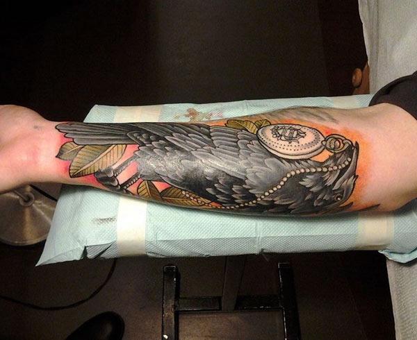 Forearm Tattoo with a black bird design make man look foxy
