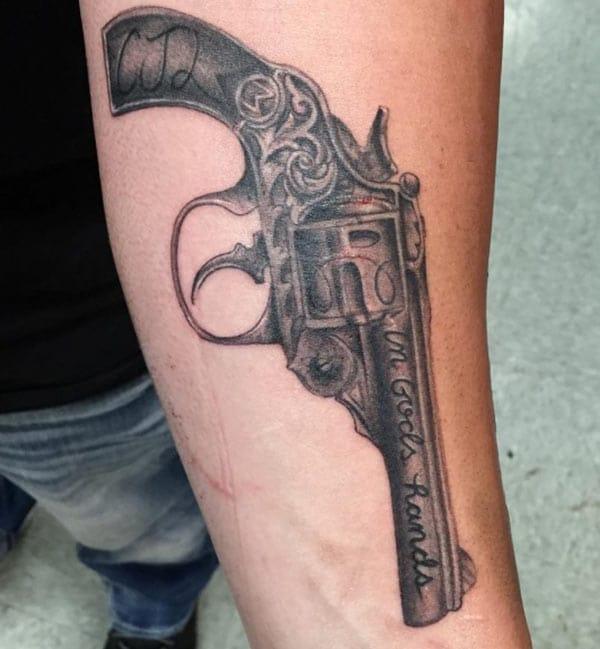 Gun Tattoo with a black ink design makes a man look elegant