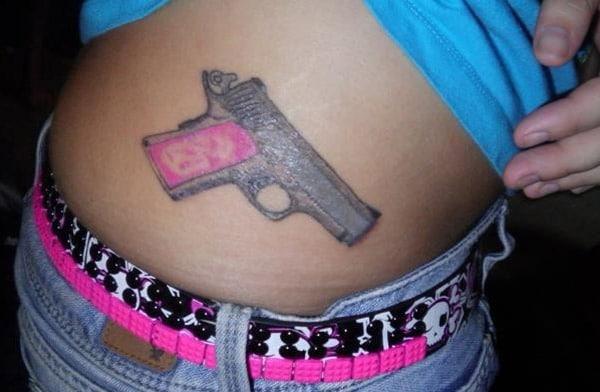 Gun Tattoo on the on the upper side hips brings a feminist look 