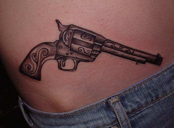 Gun Tattoo on the on the upper hips brings a feminist look