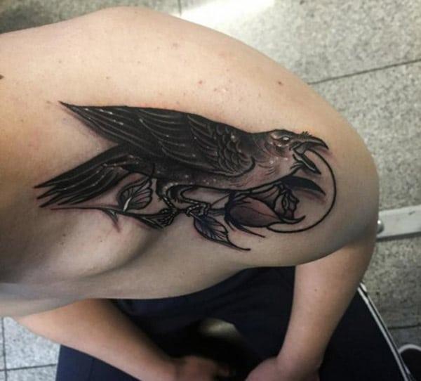 Raven tattoo on the upper shoulder brings the moralistic look in men