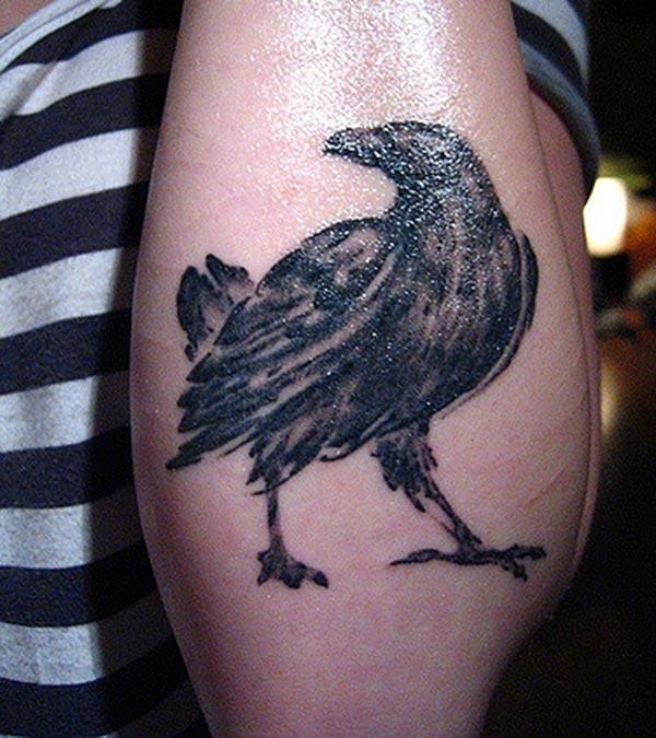 Raven tattoo on the back lower arm brings the feminist look