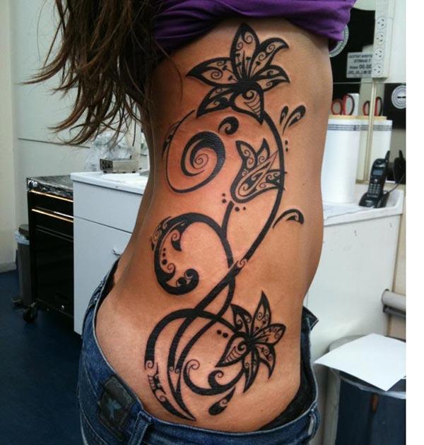 Side tattoo for Women with a black ink design flower brings a feminist look