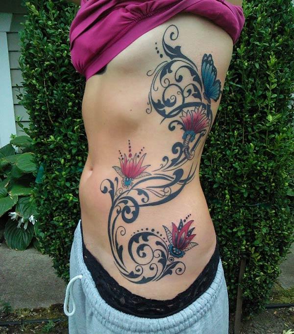 Side tattoo for Women with a black and pink flower makes them look captivating