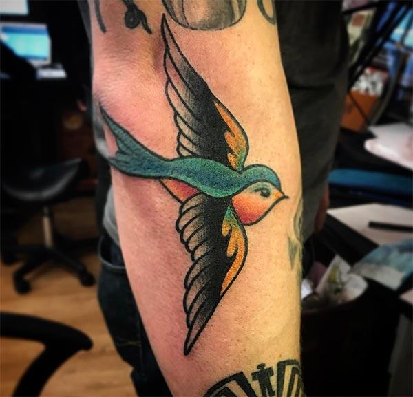 Sparrow Tattoo on the lower side arm makes a man have a dapper look