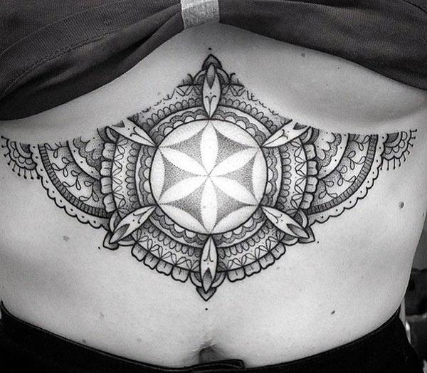 Sternum tattoo for Women with a black ink circular design make them attractive