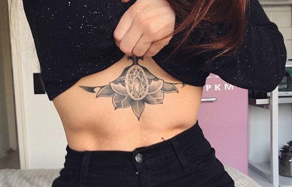 Sternum tattoo with a black ink flower design make girls attractive