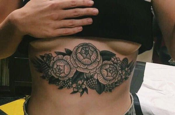 Sternum tattoo for Women with a black ink flowers makes them look enchanting 