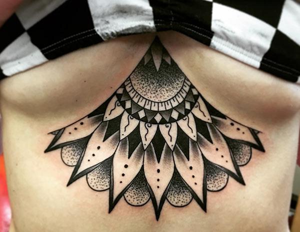 Sternum tattoo for Women with a black flower design making them look attractive