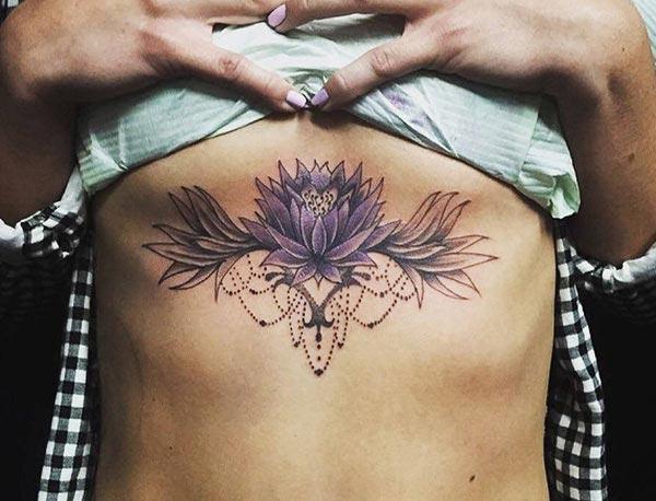 Sternum tattoo for Women with a pink ink design flower brings a feminist look