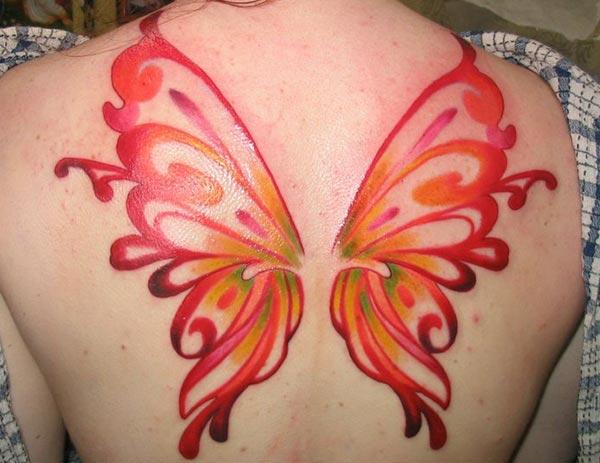 Purple ink design of the Wing tattoo on the back of women make them look attractive
