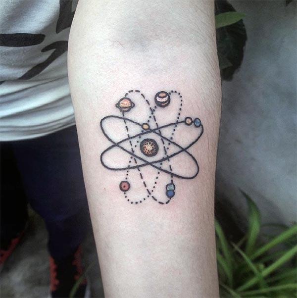This brown ink design of the Atomic Tattoo on the front lower arm matches the skin color to make a man look admirable 