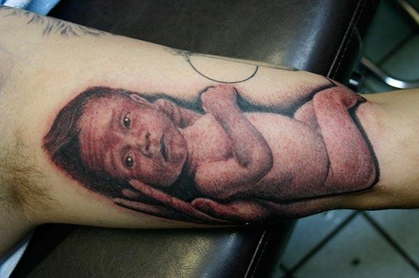 Baby tattoo for men with a brown ink design makes a man look class