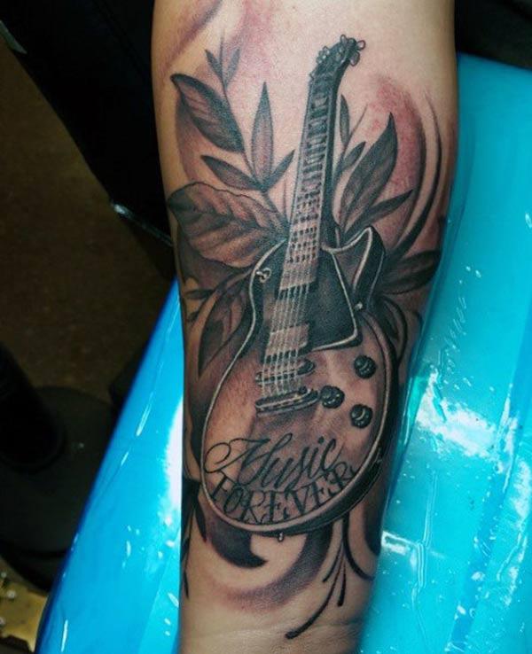 The Ink design in this Guitar Tattoo matches the skin color to make a man look magnificent