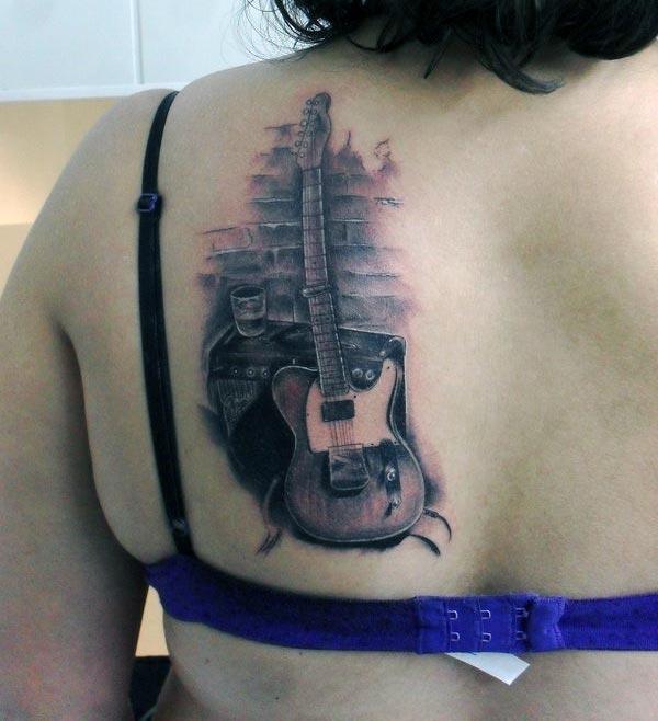 Guitar Tattoo on the back shoulder with a brown ink design brings the captivating look
