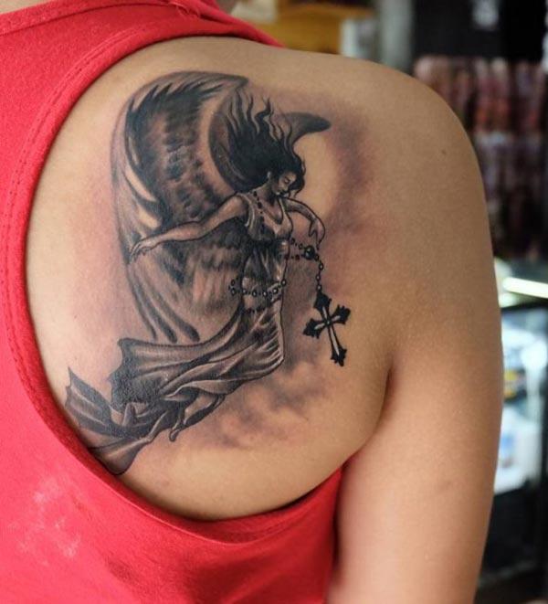 Angel tattoo at the back shoulder with a black ink design makes a girl look attractive