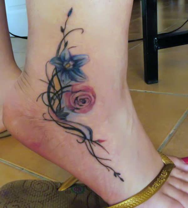 Ankle tattoo with a purple and pink ink design flower make them look attractive