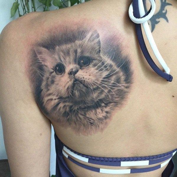 Cat tattoo at the back make a girl look astonishing
