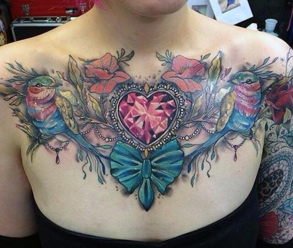 Chest Tattoo with blue and pink ink design on the chest matches the skin color of brown ladies