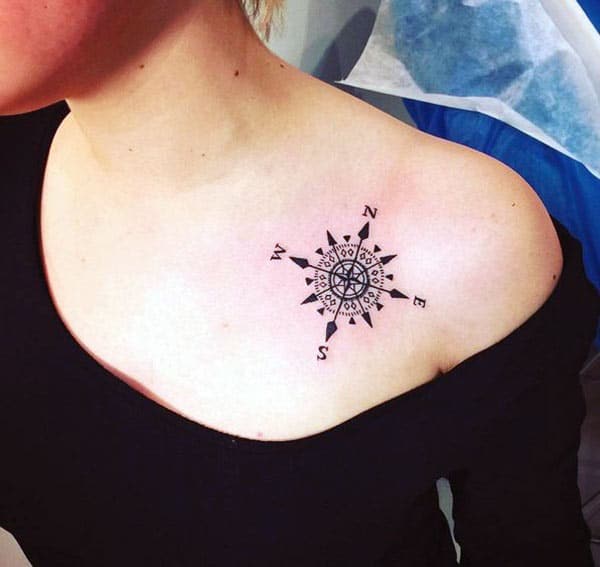 Compass tattoo on the upper chest with a black ink design make women have captivating appearance