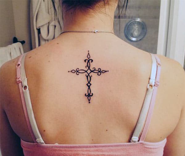 Black ink cross tattoo at girls back look captivating
