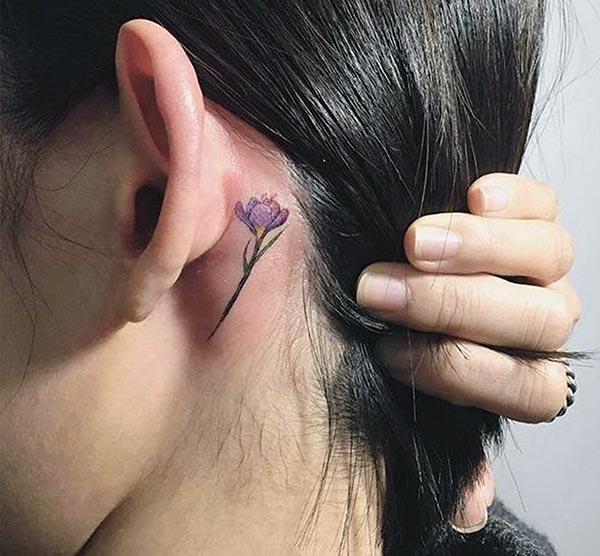 Cute tattoo behind the ear brings the feminist look