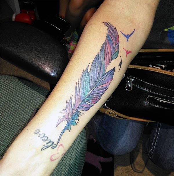 Feather tattoo on the lower arm makes a woman look captivating 